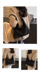 Détail du sac sous le bras noir avec bandoulière chaîne argentée et base trapèze