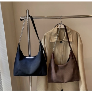 Détail de sacs fourre-tout vintage noir et café avec bandoulières en chaîne et cuir