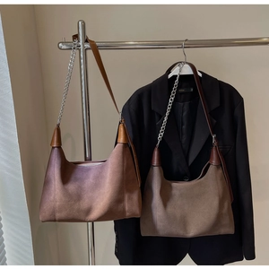 Détail du sac hobo en daim vintage avec une élégante bandoulière en chaîne argentée