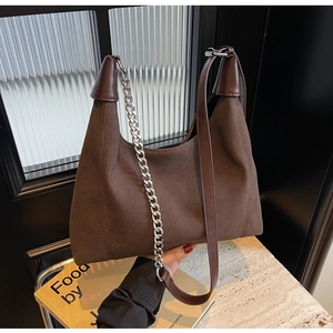 Vue détaillée du sac bandoulière en daim marron foncé avec sangle cuir et chaîne argent