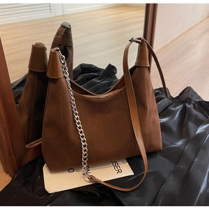 Détail du sac fourre-tout en daim marron avec chaîne argentée et fermeture à glissière