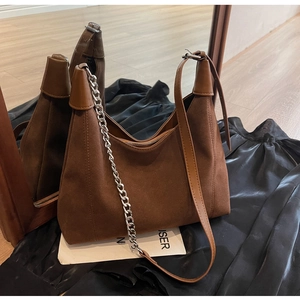 Détail du sac cabas en daim marron foncé avec chaîne argentée et bandoulière cuir