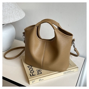 Detail view of a camel lychee grain bucket bag on a minimalist lifestyle background