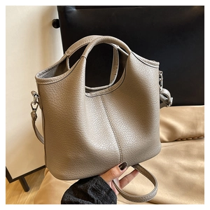 Detailed view of taupe bucket bag showing pebble leather texture and metal hooks