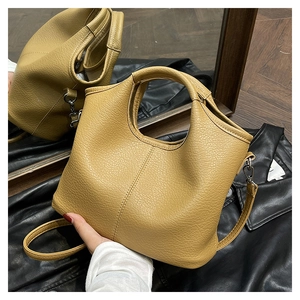 Macro detail of warm yellow litchi grain leather texture and vertical stitching on bag