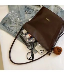 Flat lay of vintage dark brown tote bag with tablet and phone showing large capacity