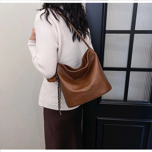 Detail of dark brown vintage faux leather shoulder bag featuring textured oily finish