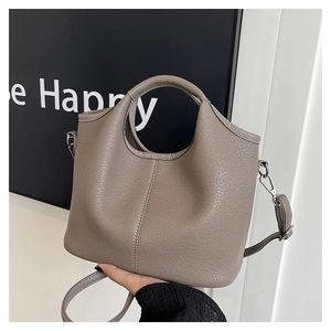 Macro view of taupe litchi texture leather bucket bag with silver metal hooks