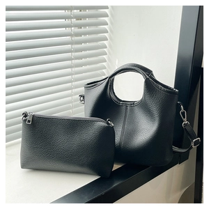 Detail of black lychee texture tote set with round cutout handle and silver hardware