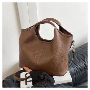 Detail of a brown lychee pattern leather tote bag with silver hardware and shoulder strap