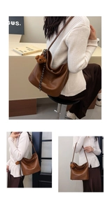 Detail of a brown leather crescent shoulder bag featuring a cute plush bear pendant
