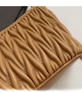Dettaglio ravvicinato della pelle trapuntata marrone su una borsa a tracolla da donna