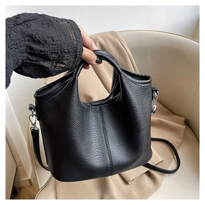Close-up of black litchi grain leather bucket bag with silver metal buckles and stitching