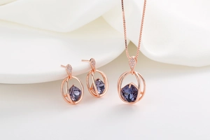 Detail of rose gold jewelry set featuring purple faceted crystal and micro-pave diamonds