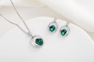 Macro view of emerald-cut green crystal jewelry set with water drop diamond accents