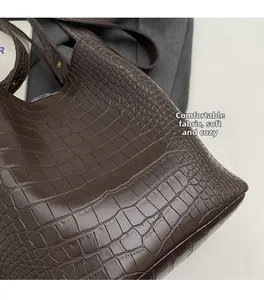 Close-up of the dark brown crocodile pattern texture on a soft leather tote bag