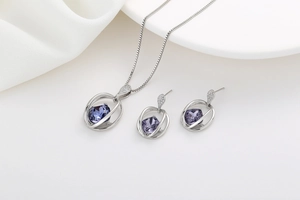 Detailed view of silver crystal jewelry set with purple gemstones and micro diamonds