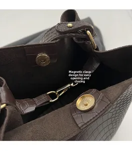 Detail of dark brown crocodile pattern leather bag with gold magnetic snap closure