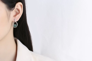 Detail of elegant emerald green crystal earrings with S925 silver and white diamonds