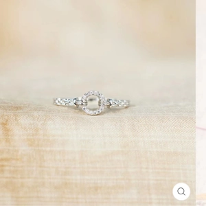 Detailed view of cubic zirconia circle ring with a silver braided chain band design