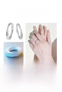 Dettaglio degli anelli Mobius per coppia con fascia liscia uomo e anello donna zirconi