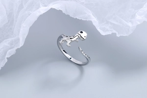 Macro detail of adjustable silver dinosaur ring featuring intricate black bone textures
