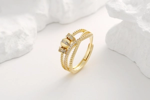 Macro detail of gold multi-layer cross ring with cubic zirconia and rotatable bead feature