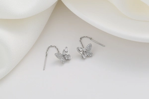 Detailed view of silver butterfly tassel earrings with sparkling zircon inlay details