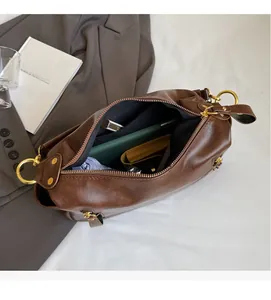 Deep brown leather tote bag interior showing large capacity and golden hardware details