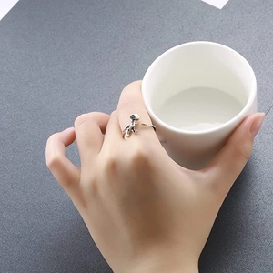 Adjustable silver dinosaur open ring featuring a cute T-Rex shape on a female model hand