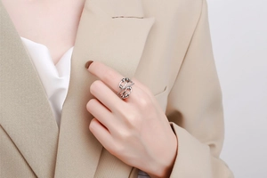 Detail of silver fidget ring with movable beads on model wearing a beige blazer