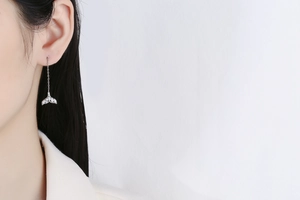 Detailed view of silver mermaid tail threader earrings with shimmering crystals on model