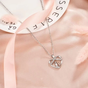 Collier cœur gravé 'I love you forever' sur un fond élégant en soie rose brillante