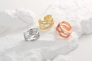 Detail of adjustable crisscross rings in gold, silver, and rose gold with zircon micro-pave