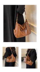 Detail view of brown vintage hobo bag featuring vertical zippers and side pockets