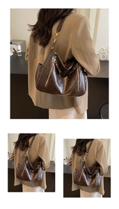 Detail of dark brown tote bag with natural leather texture and golden metal hardware