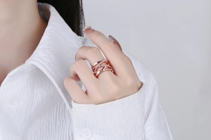 Detail of rose gold multi-layer criss-cross ring with pavé diamonds on finger