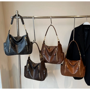 Detail view of four vintage leather tote bags in brown, coffee, caramel and black colors