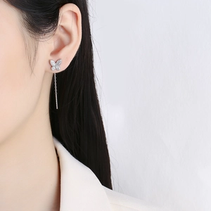 Silver butterfly earrings with long tassel chain and micro-pave diamonds on model