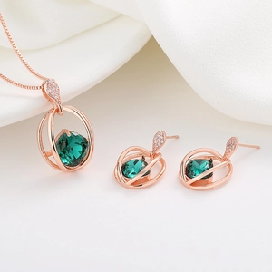Elegant rose gold jewelry set with emerald green crystals and sparkling zircon accents