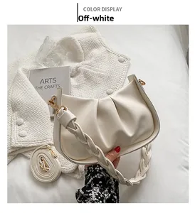 Détail du sac à main plissé blanc cassé avec poignée tressée et bandoulière amovible