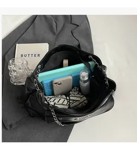 Spacious interior of a black leather tote bag with silver chain, showing ample storage space
