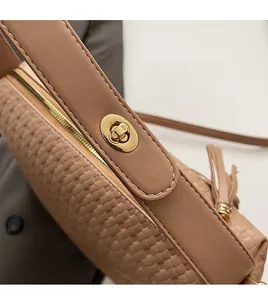 Détail du sac en cuir tressé marron clair avec fermoir doré et coutures précises