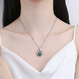 Elegant silver necklace with emerald cut gemstone pendant worn by a female model