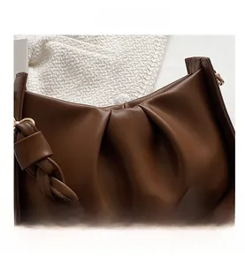 Détail du sac nuage plissé marron foncé avec une texture de bandoulière tissée unique