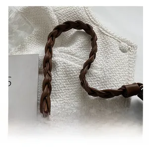 Détail macro d'une poignée en cuir marron tressé avec un savoir-faire artisanal précis