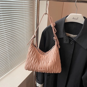 Detail of pink pleated crossbody bag with matelassé texture and adjustable strap