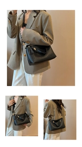Détail du sac à bandoulière tressé noir avec glands en cuir et boucle magnétique