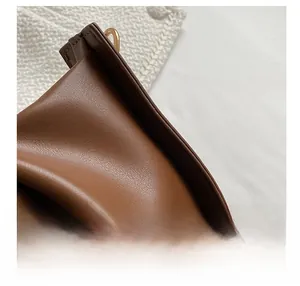 Détail des coutures fines et de la texture en cuir de qualité d'un sac à main marron