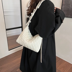 Detail of white pleated hobo bag showing the vertical wave texture and soft leather